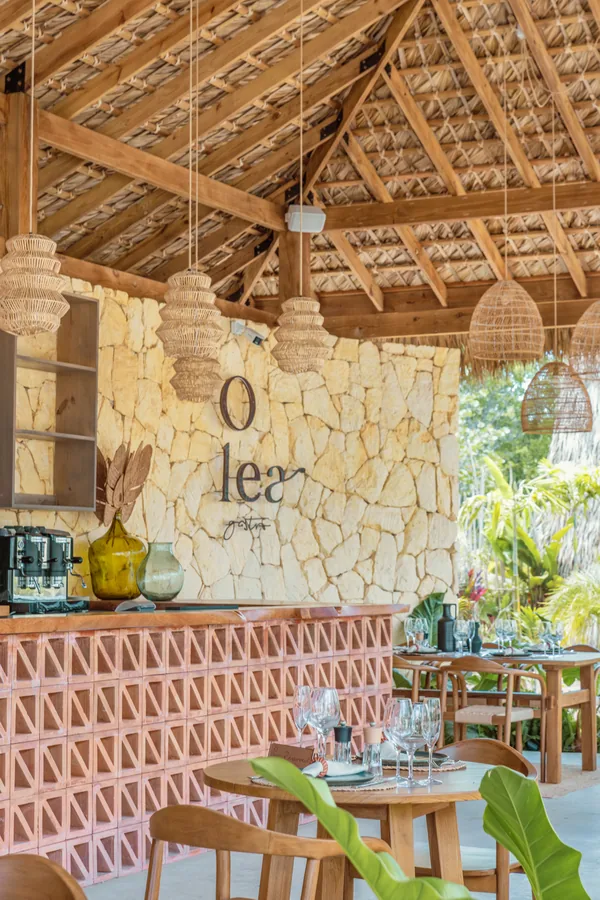 La barra de Olea con el rótulo sobre la piedra y las lámparas de mimbre