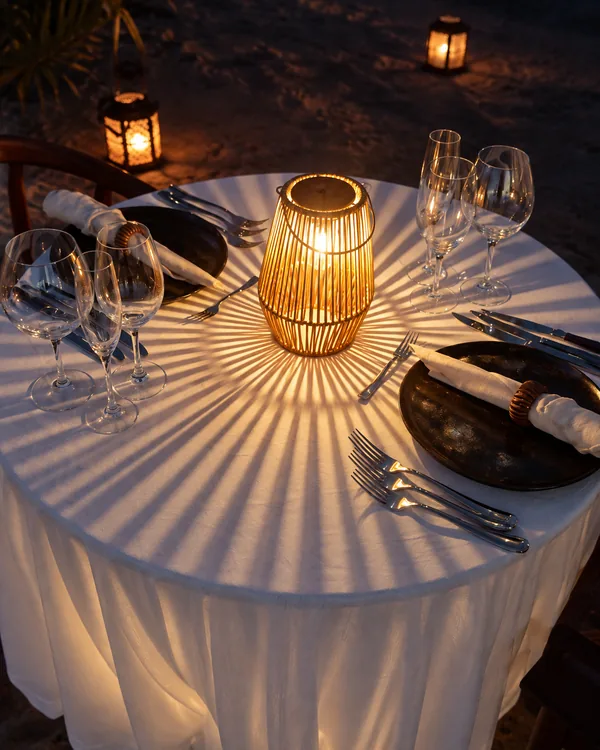 Recreación · La mesa puesta: mantel blanco, farol de mimbre y cristalería