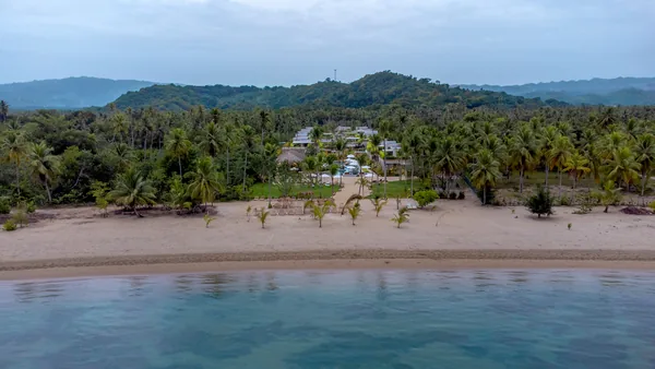 La playa y el cocoteral desde el mar, con Amares al centro
