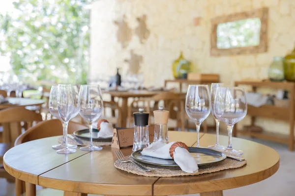 Mesa puesta en la sala: copas, platos negros y servilleta de lino